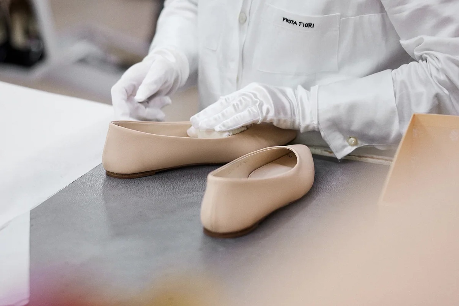 Prota Fiori artisan in a branded atelier coat finishing nude leather flats